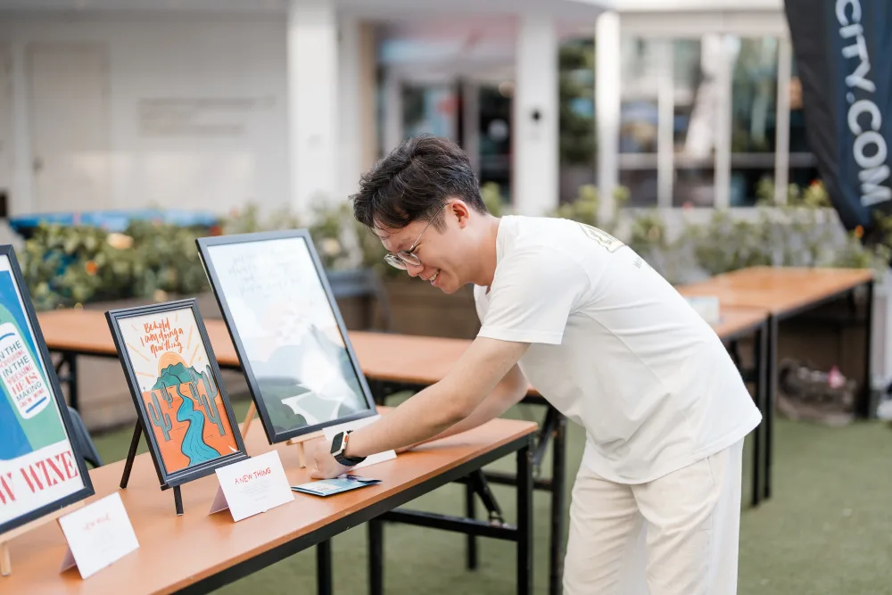 Timothy Loo, founder of Four One Two, setting up scripture art prints at a market stall